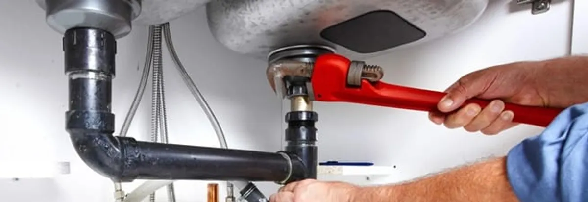 Garbage disposal repair technician tightening the sink drain and disposal connection in Mobile, AL